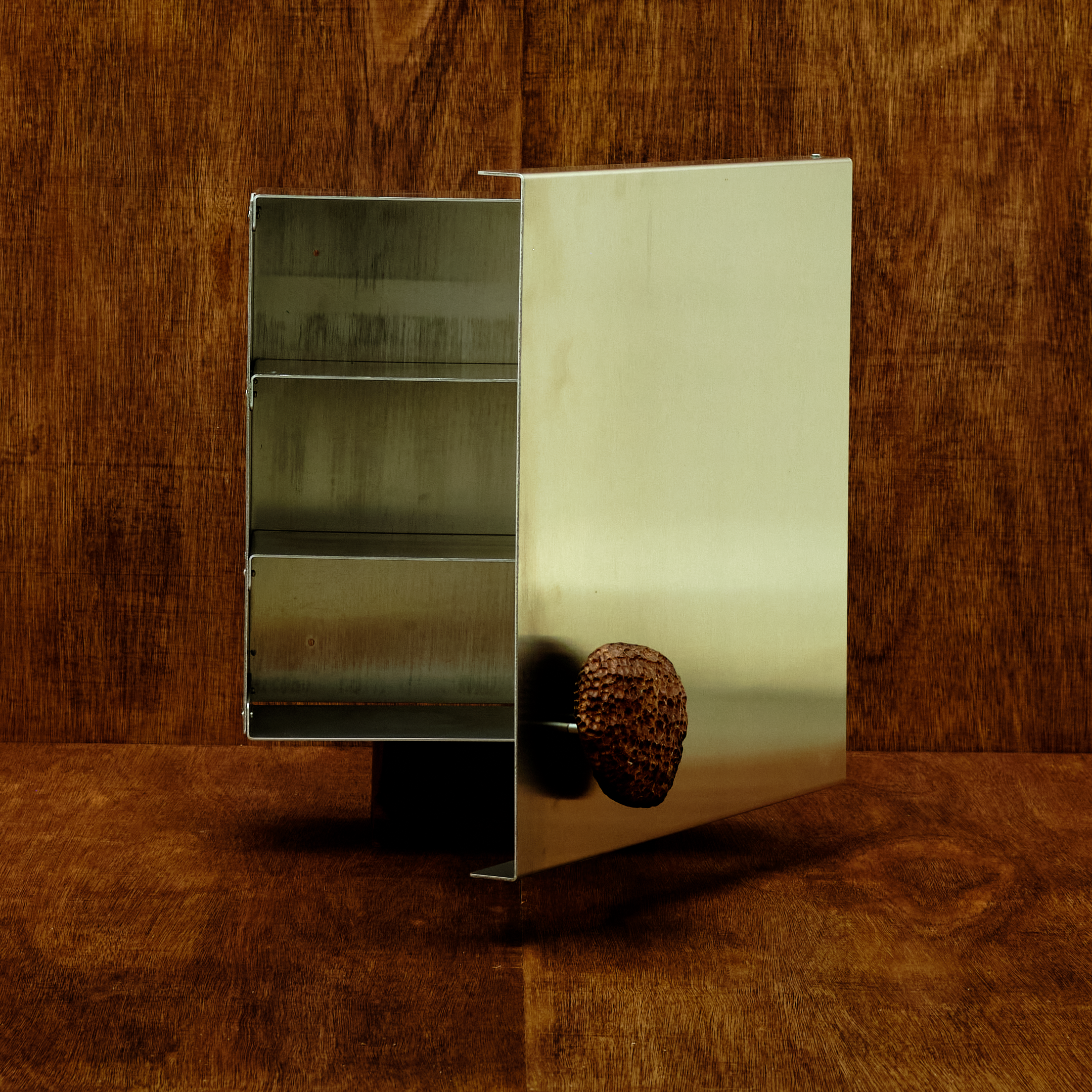 Metallic cabinet with a textured knob on a wooden background