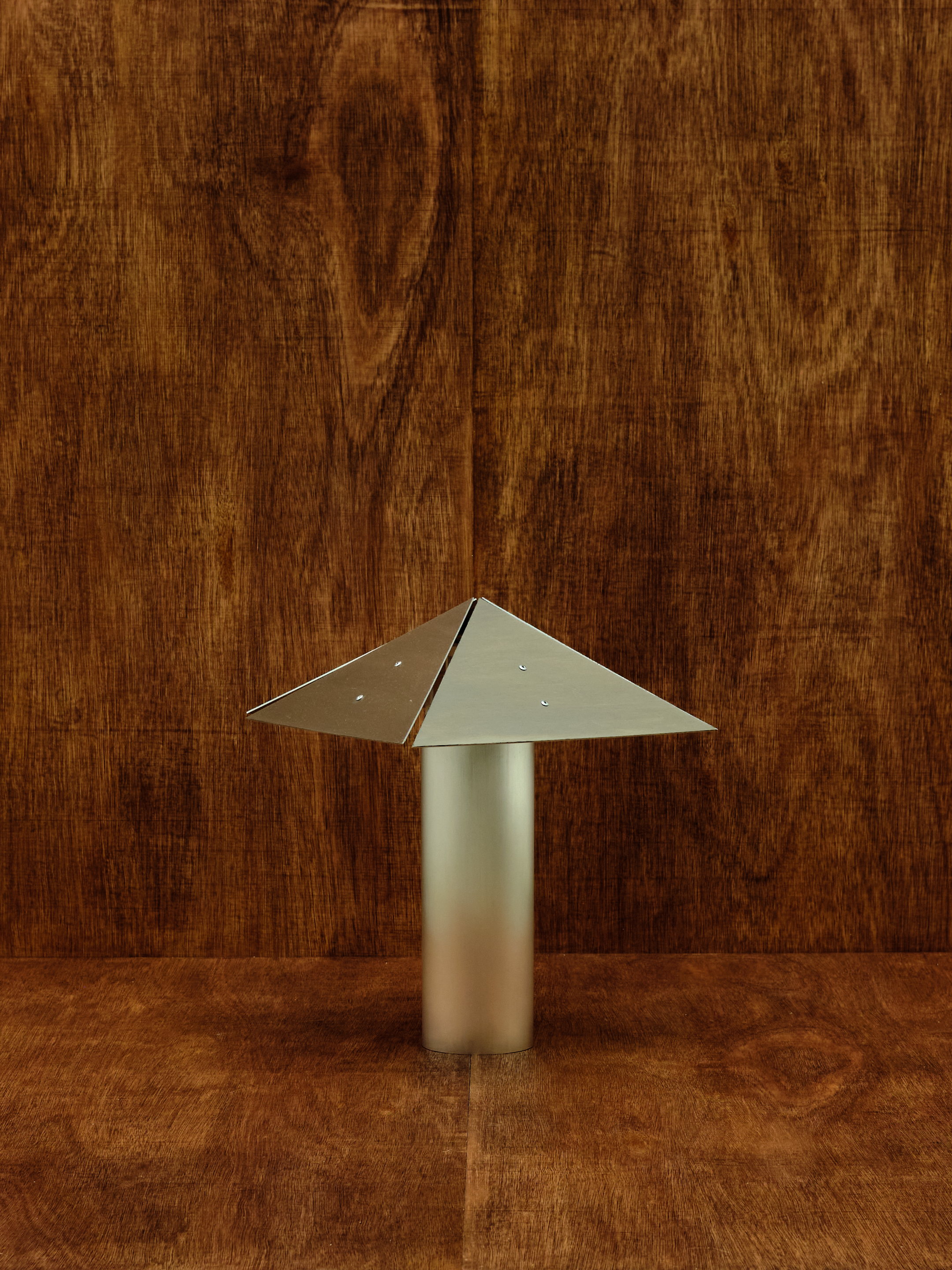 Metallic table lamp on a wooden surface.