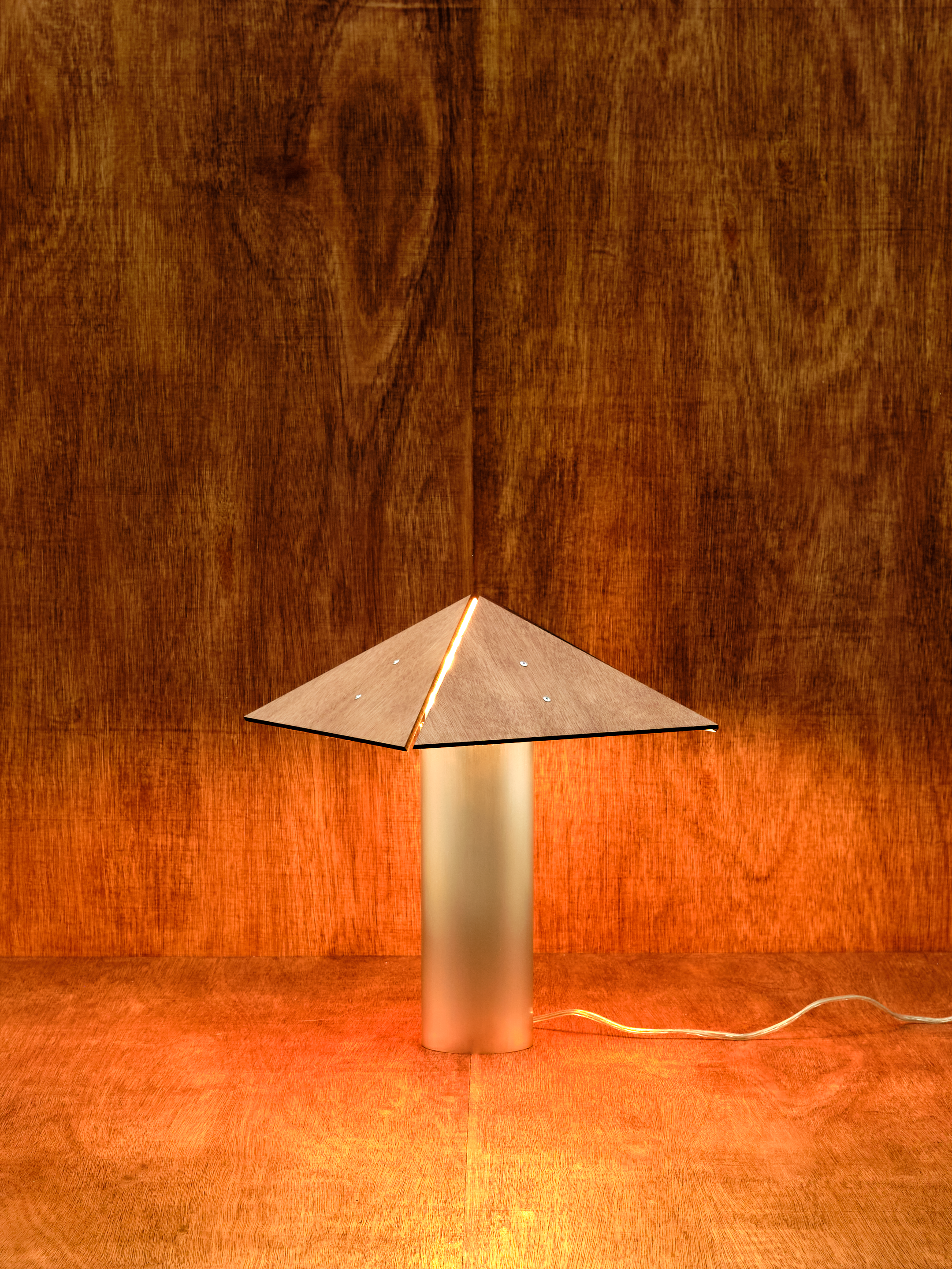 Metallic lamp with a geometric design on a wooden surface