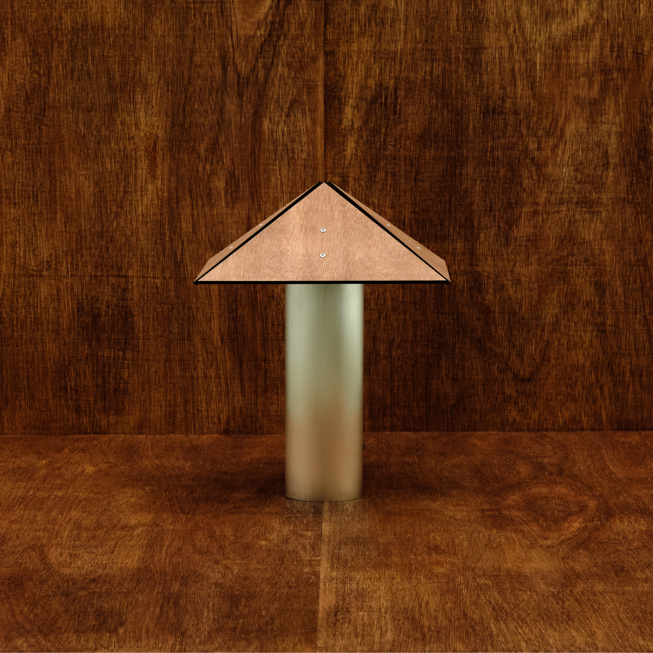 Decorative lamp with a brown geometric shade on a wooden background
